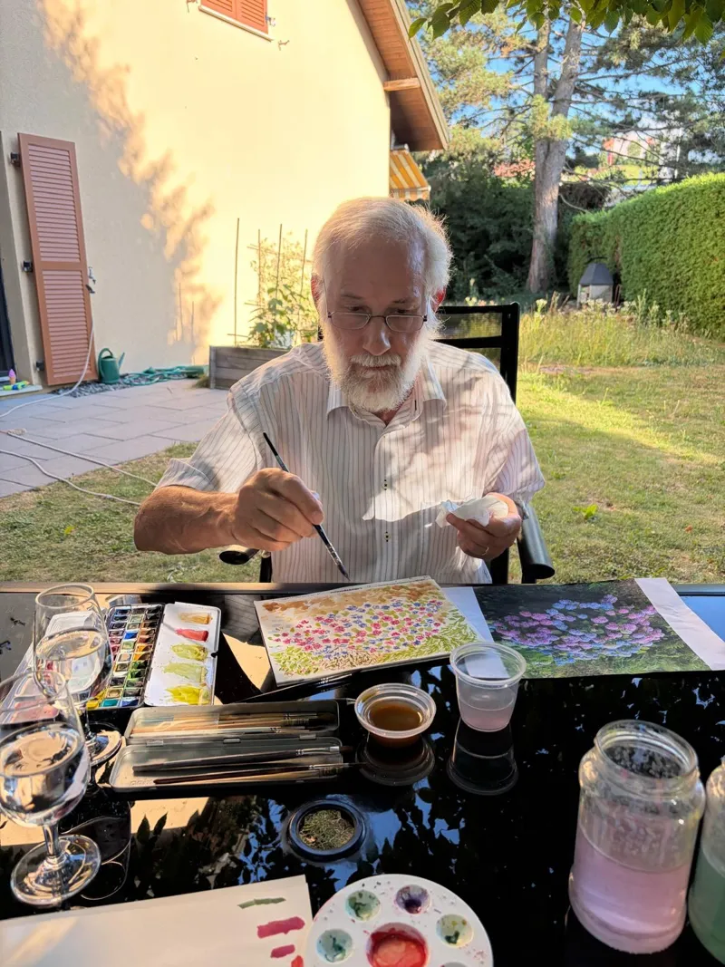 Cours pour adultes en plein air : participants peignant autour d'une table.